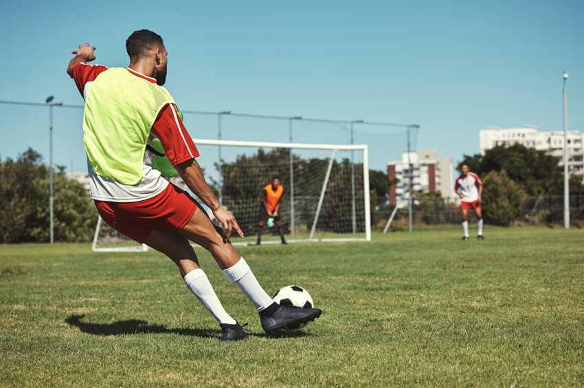 Homme jouant au foot prêt à marquer un but 