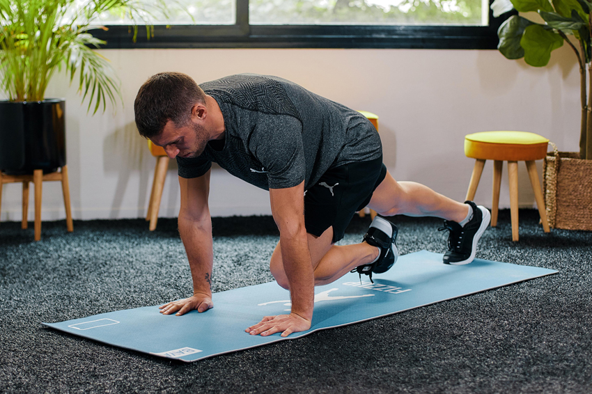 Homme effectuant des mountain climber dans son salon