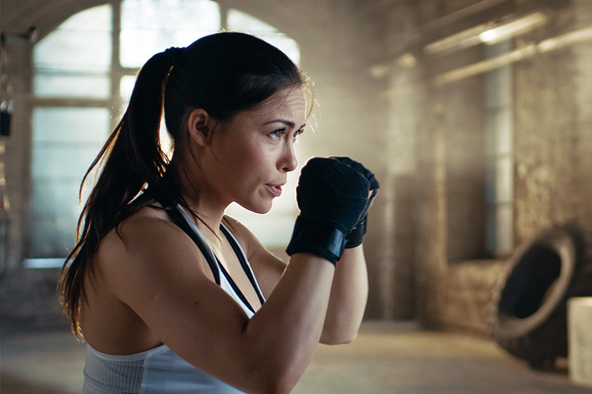 Une femme est en position de garde de boxe.